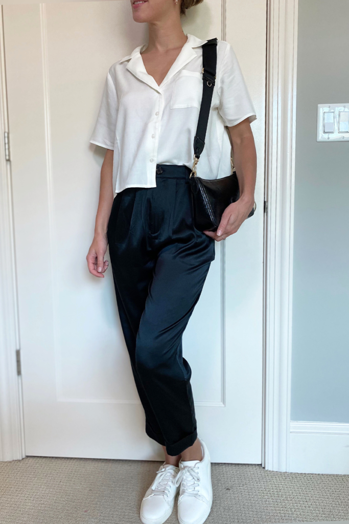 Silk pants combines with classic cut, white shirt with black crossbody bag and white sneaker shoes. Stay timeless.